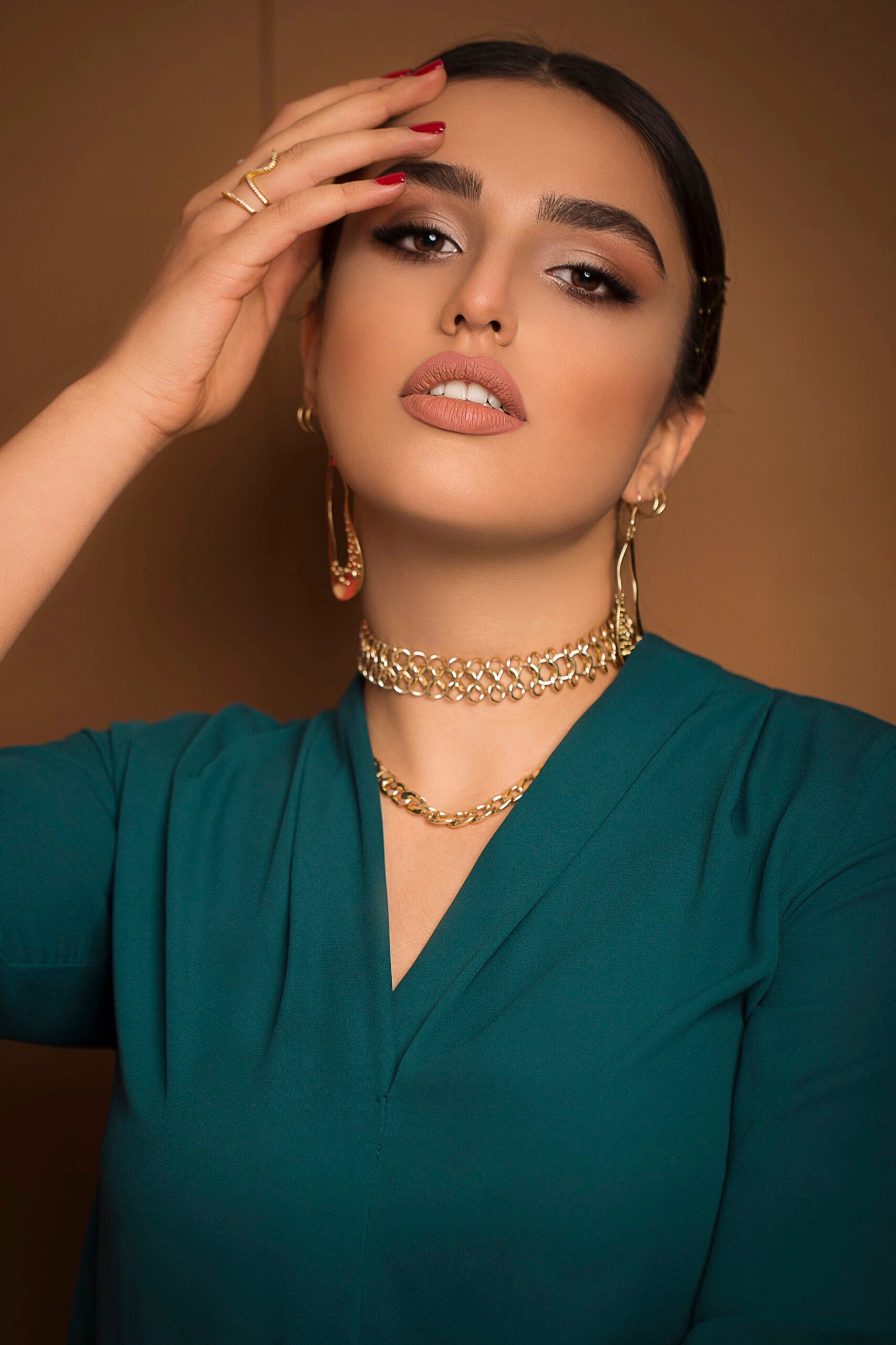 Model wearing a gold choker and earrings