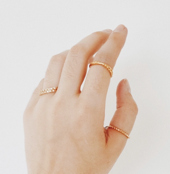 Hand wearing gold rings