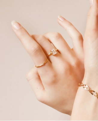 Hand wearing a gold diamond ring and bracelet